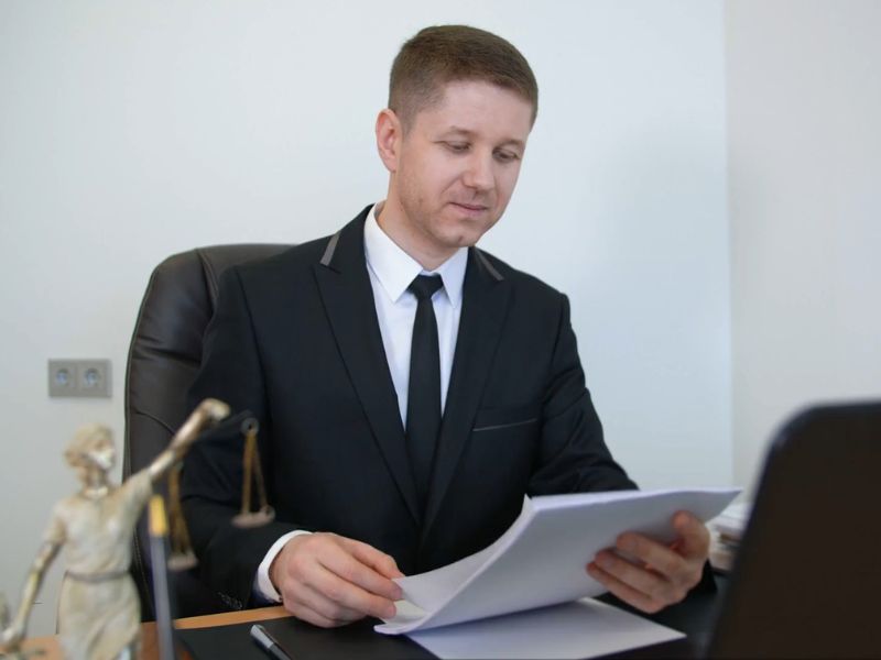 advokat u svojoj kancelariji lista papire