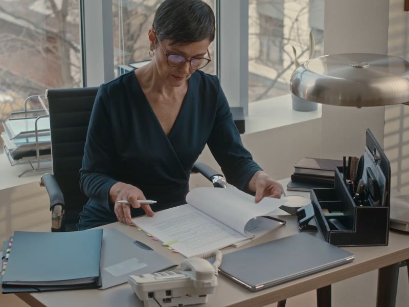 advokatica sedi u svojoj kancelariji i popunjava papire